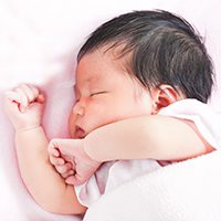 Newborn baby sleeping in bed.
